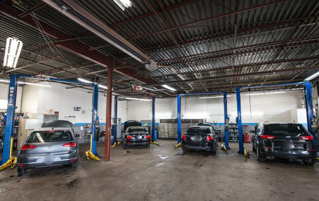 Inside the Auto Trust Centre service bays — vehicles on lifts at the Mississauga shop
