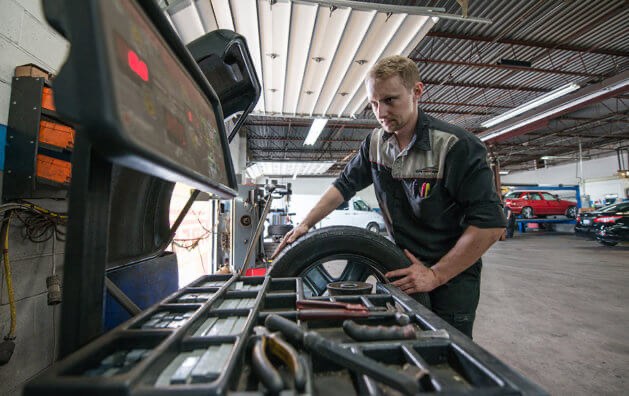 Technician mounting a tire at Auto Trust Centre